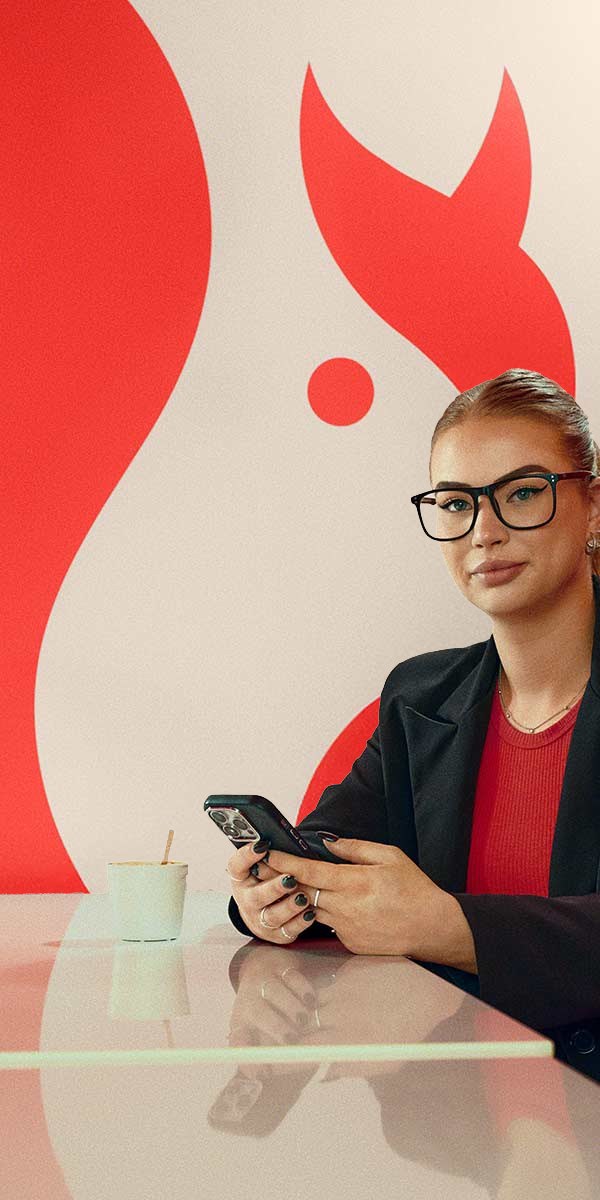 Chantal aan tafel met haar telefoon, voor de rode eekhoorn van ASN