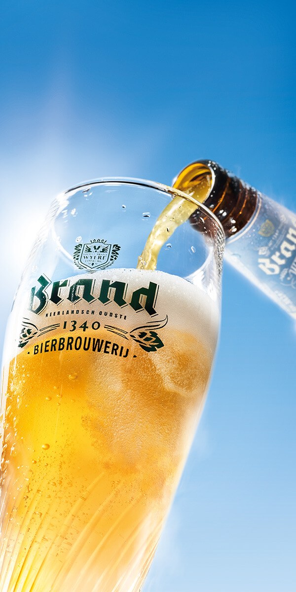 Brand Weizen wordt tegen een blauwe lucht in een glas geschonken