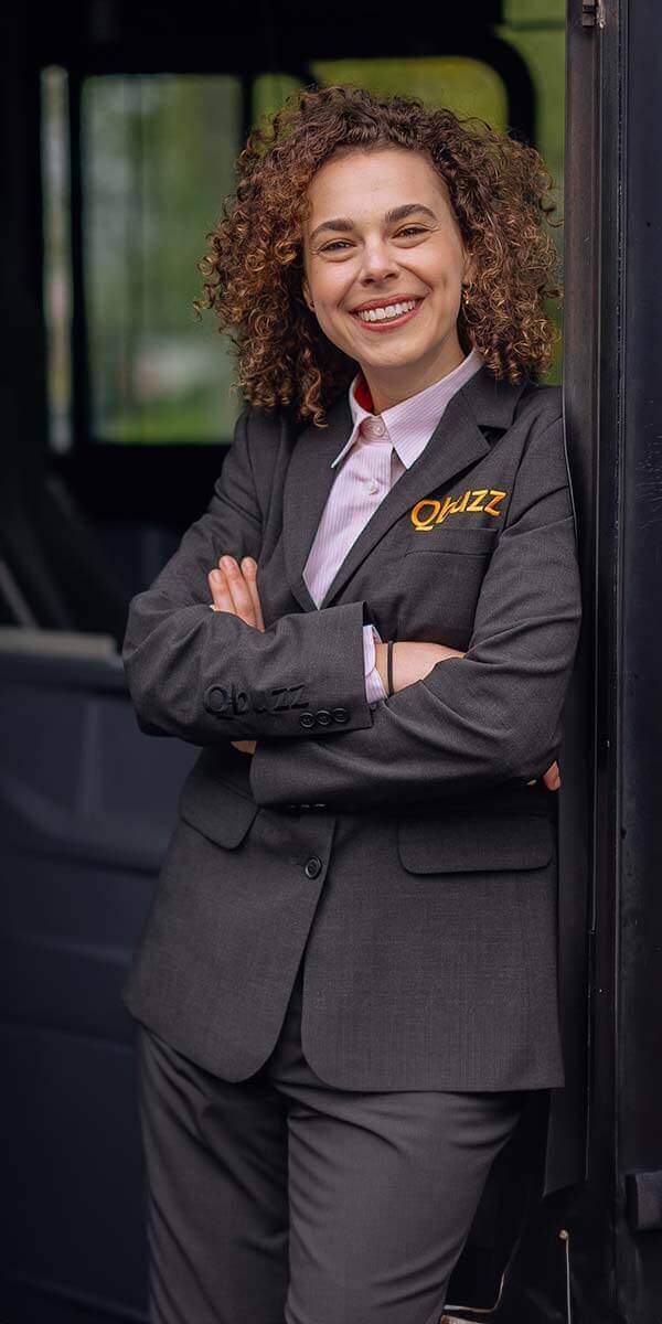 Een chauffeur van Qbuzz met de armen over elkaar in de deur van de bus