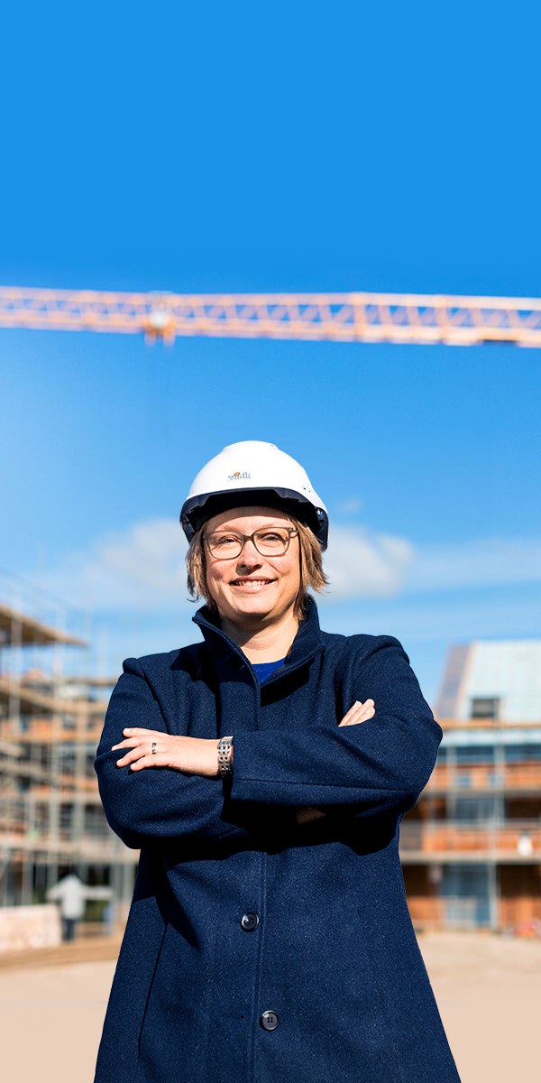 Ellen met witte helm voor een bouwplaats