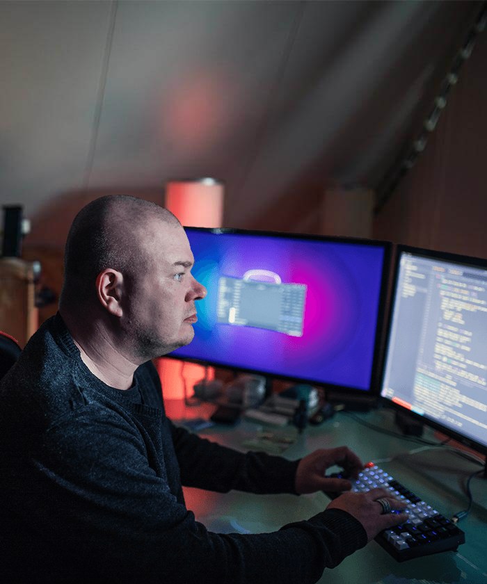 Maikel achter twee schermen met code