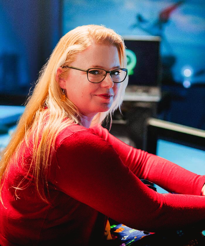 Renske in een rode trui voor een scherm