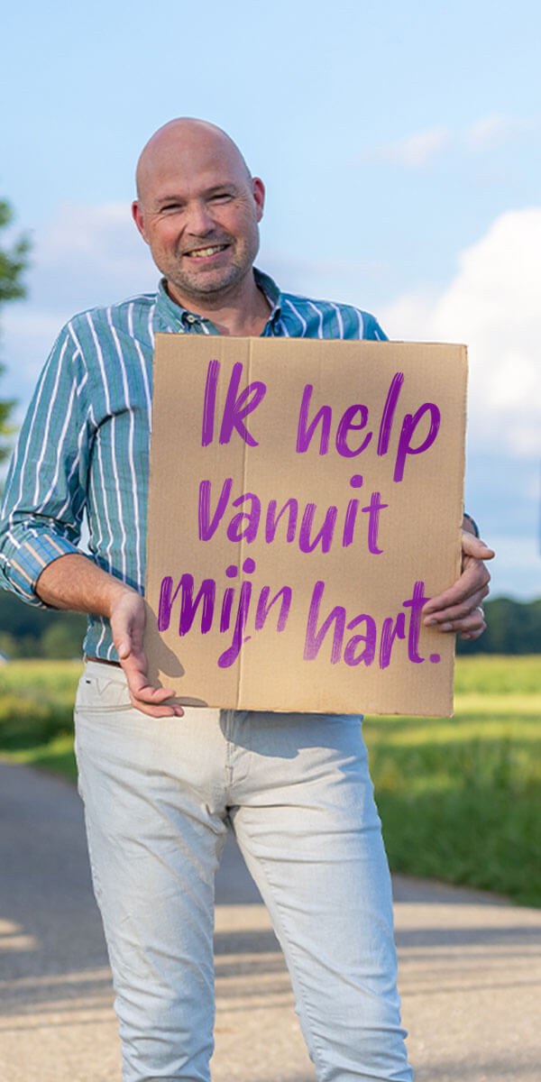 Vrijwilliger met het bord Ik help vanuit mijn hart