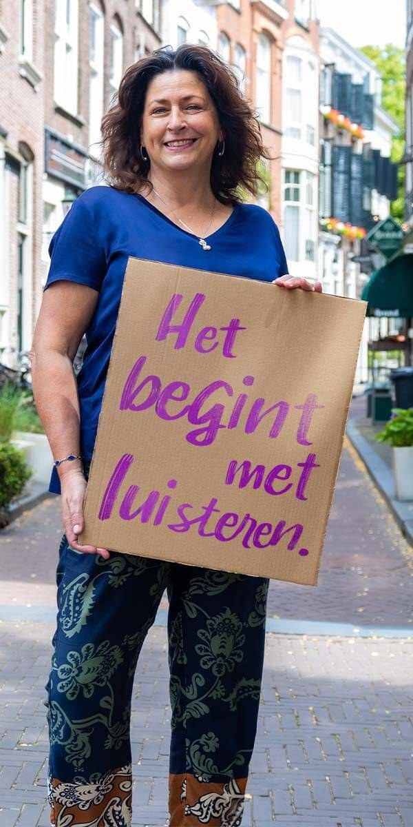 Vrijwilliger met het bord Het begint met luisteren