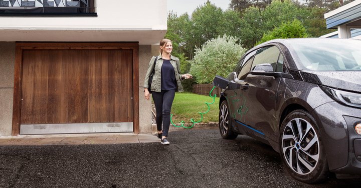 Native beeld: vrouw bij haar elektrische auto