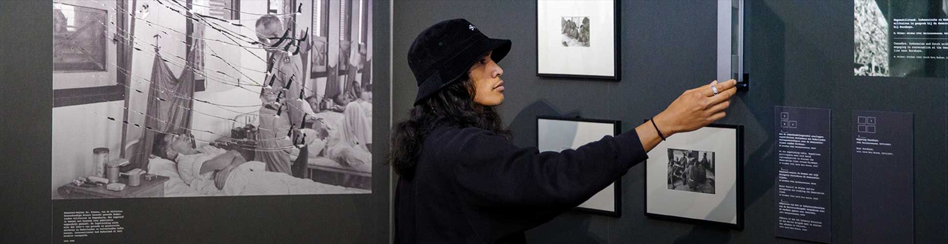 Een bezoeker wijst naar een foto in de expo