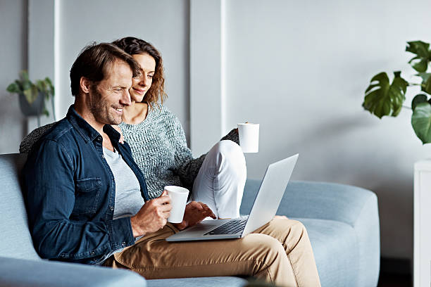 Shot of a mature couple sitting on their sofa using a laptop