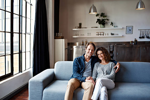 Portrait of a content mature couple sitting on their living room sofa